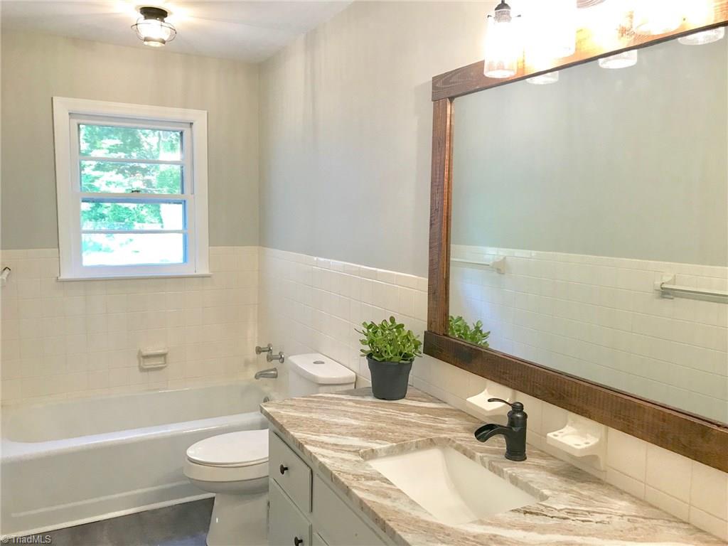 2629 Weymoth Road Winston-Salem, NC 27103 - Photo 14 of 22 Hall Bathroom features custom granite top, rustic mirror frame and new lighting & plumbing fixtures.