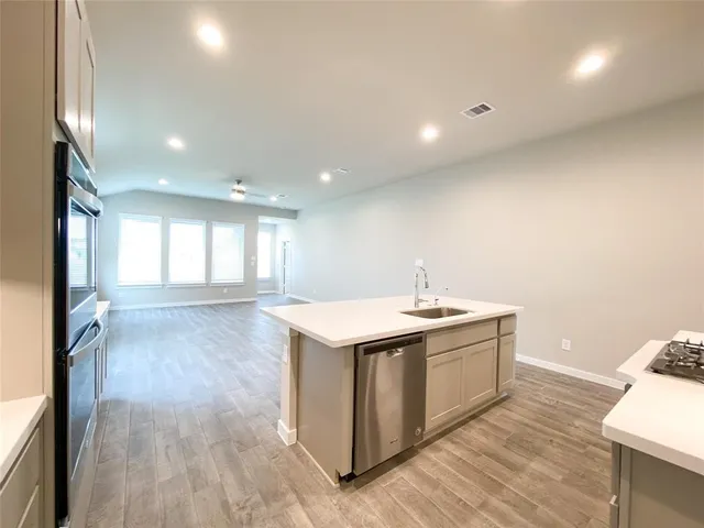 a kitchen with a sink and wooden floor