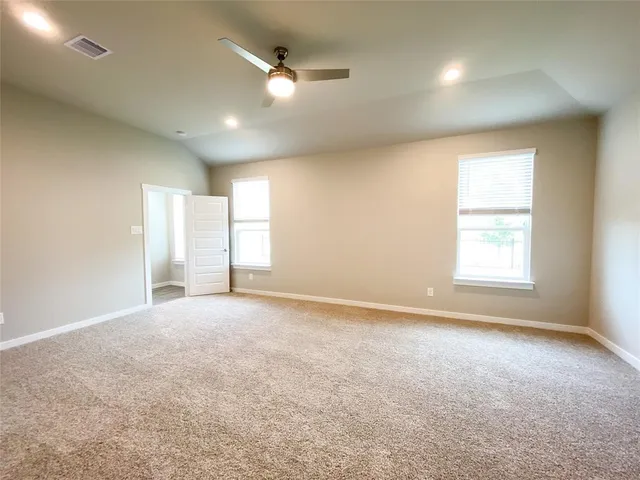 an empty room with windows and fan