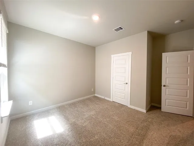 an empty room with closet and windows