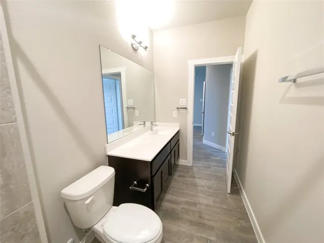 a bathroom with a toilet a sink and mirror