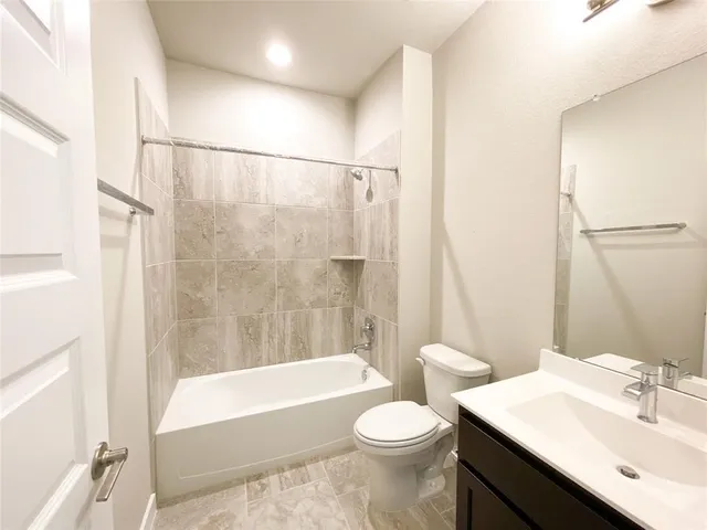 a bathroom with a sink a toilet a mirror a bathtub and shower