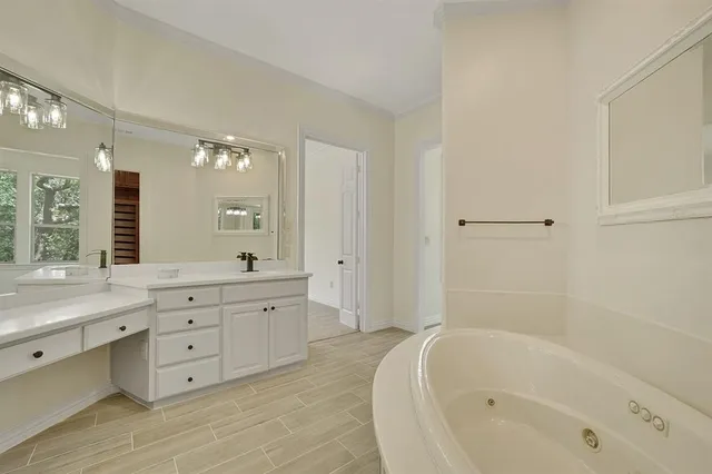 a spacious bathroom with a tub sink double and mirror