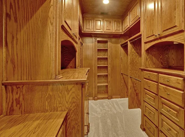 a view of an empty room with a window and a kitchen