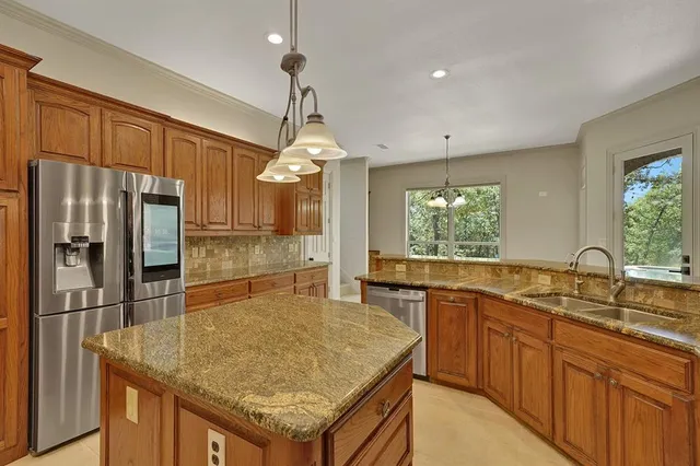 a kitchen with stainless steel appliances granite countertop a sink refrigerator and cabinets