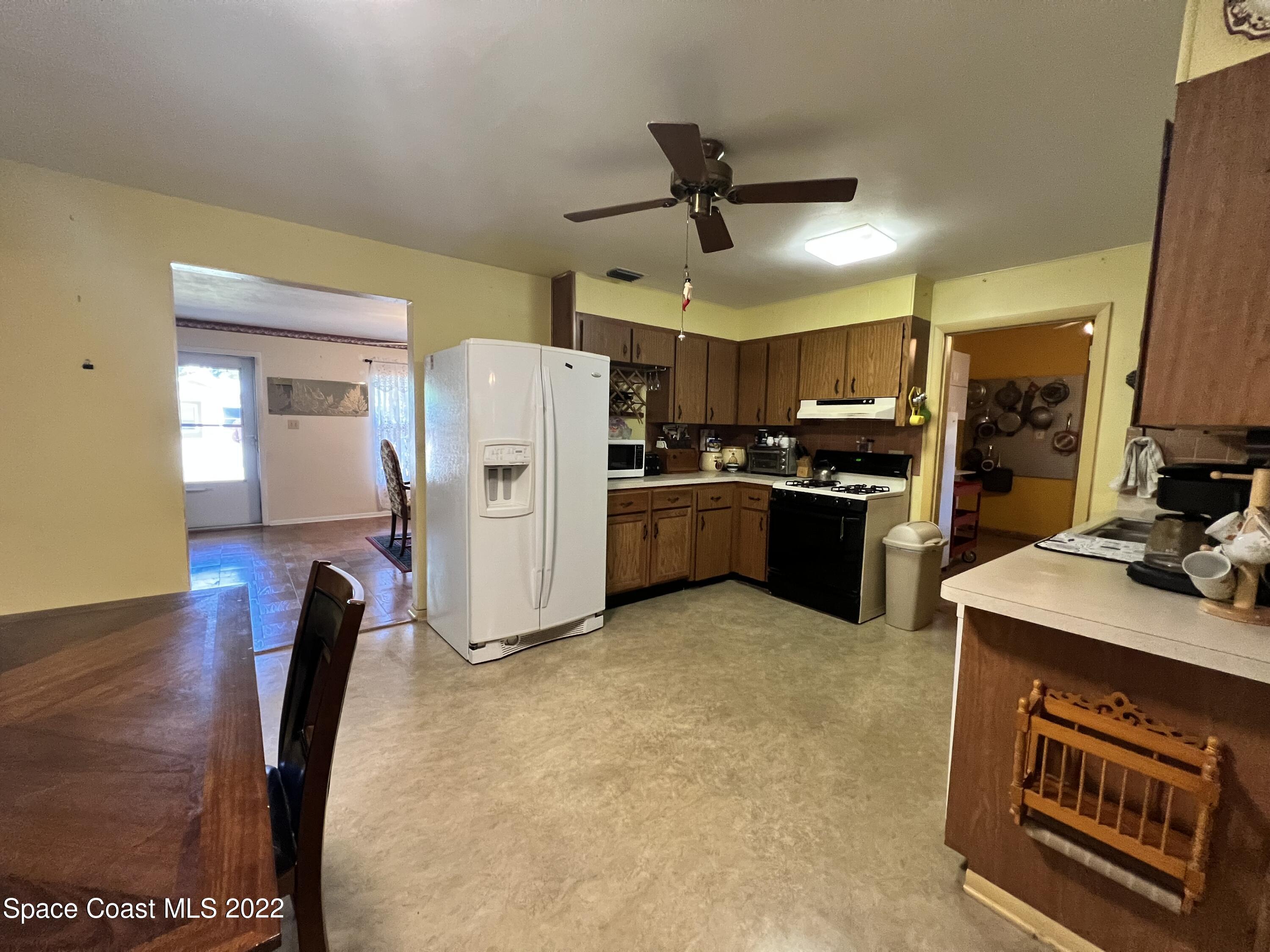 974 Macco Road Cocoa, FL 32927 - Photo 4 of 12 a kitchen with refrigerator and microwave