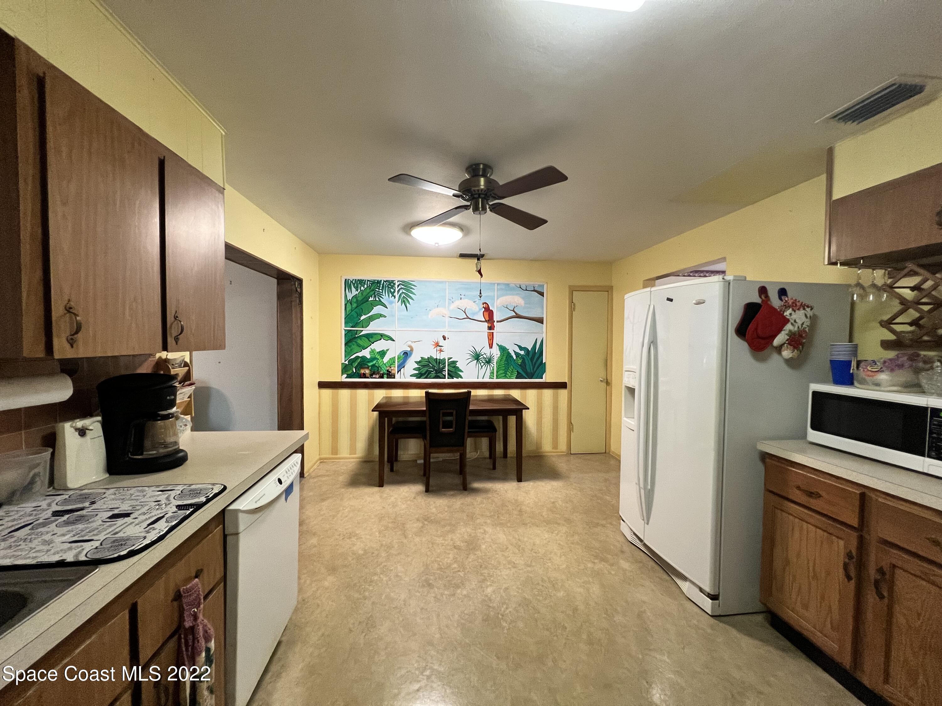 974 Macco Road Cocoa, FL 32927 - Photo 5 of 12 a kitchen with microwave a stove and refrigerator