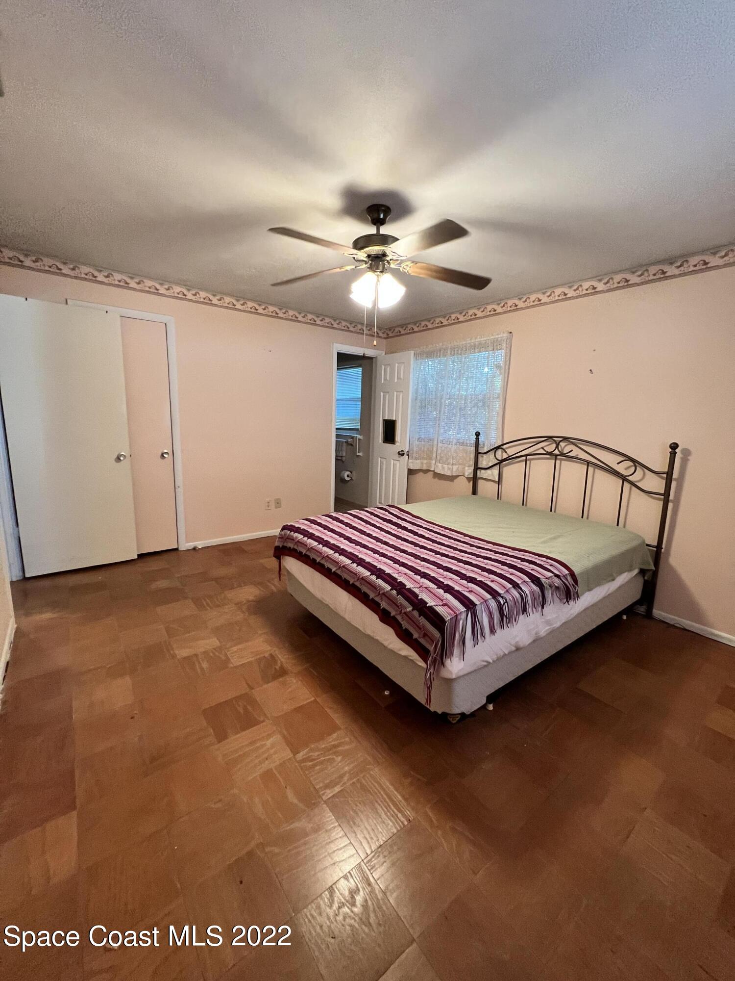 974 Macco Road Cocoa, FL 32927 - Photo 9 of 12 a bedroom with a bed and ceiling fan