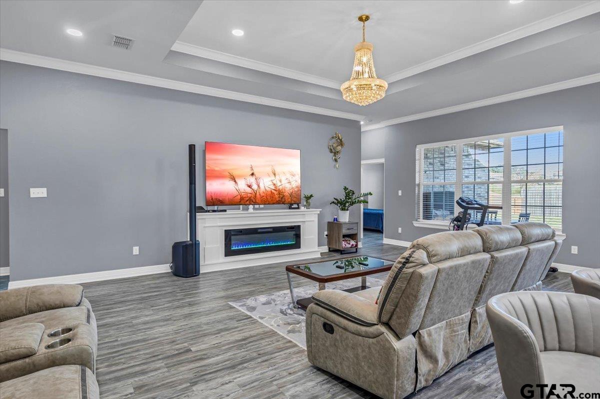 1603 Elk River Road Tyler, TX 75703 - Photo 7 of 43 a living room with furniture a chandelier and a flat screen tv
