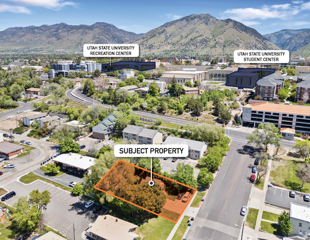 Aerial perspective showcasing a parcel of land with mature trees, bordered by a paved street and other properties
