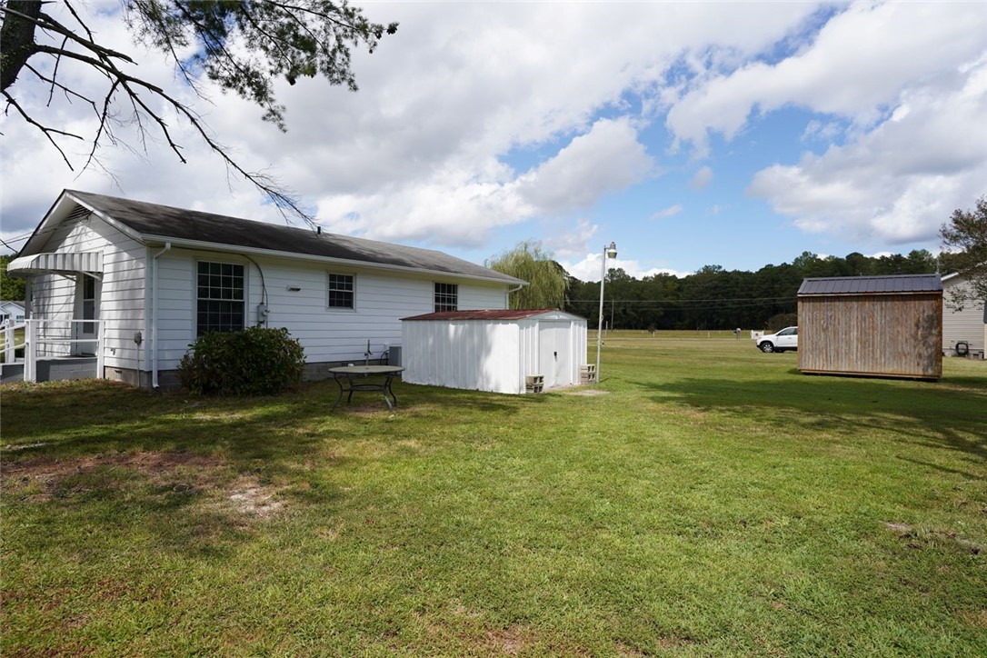 11753 Harcum Road Gloucester, VA 23061 - Photo 4 of 27 Back of property featuring a storage unit and lawn