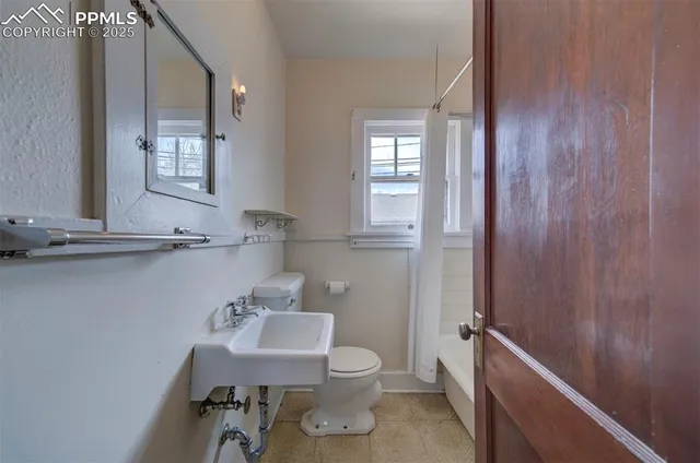 a bathroom with a toilet a sink and mirror