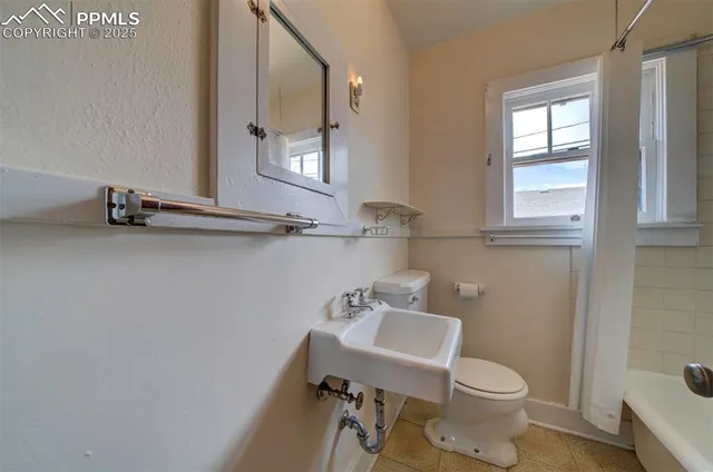 a bathroom with a toilet a sink and a mirror