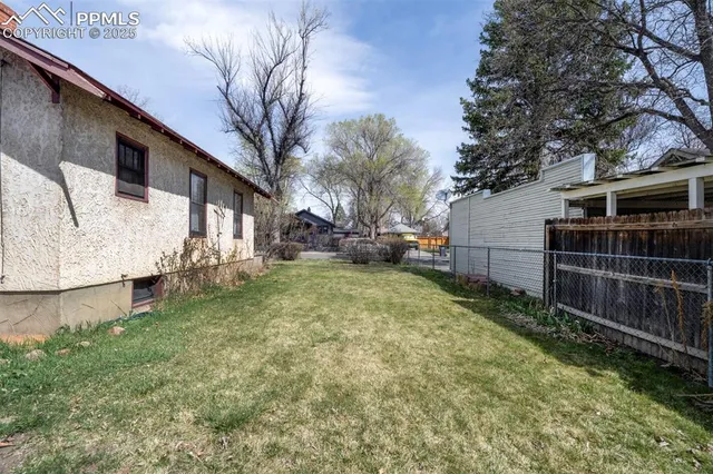 a view of backyard with wooden fence