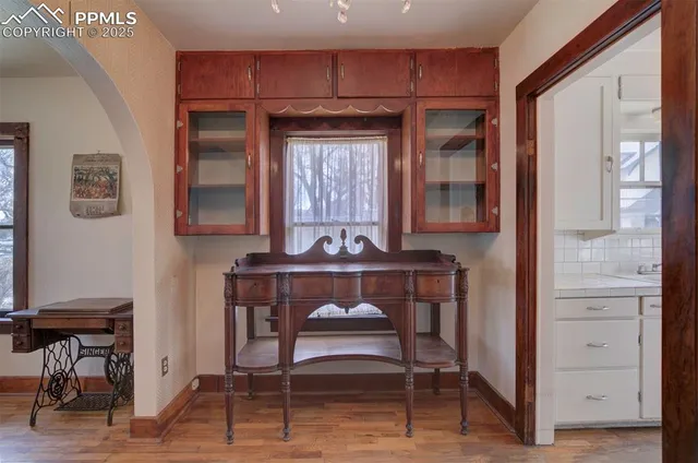 a living room with a table chairs and a window