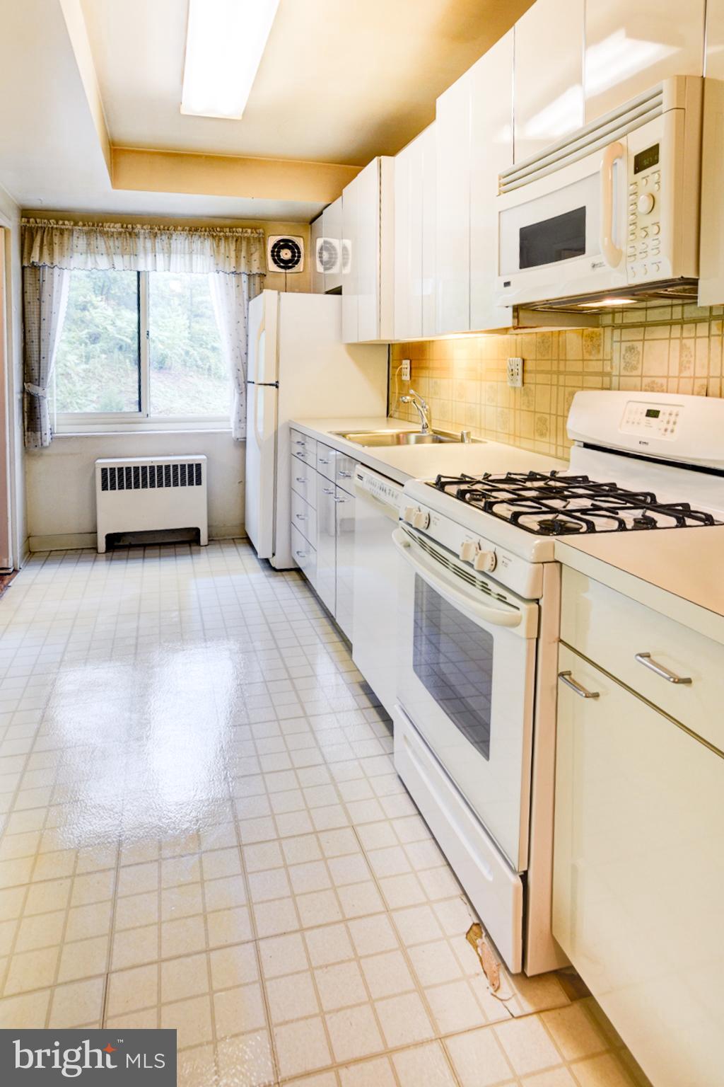 4201 Cathedral Avenue Northwest, Unit 201E Washington, DC 20016 - Photo 12 of 66 a kitchen with stainless steel appliances granite countertop a stove a sink and a refrigerator