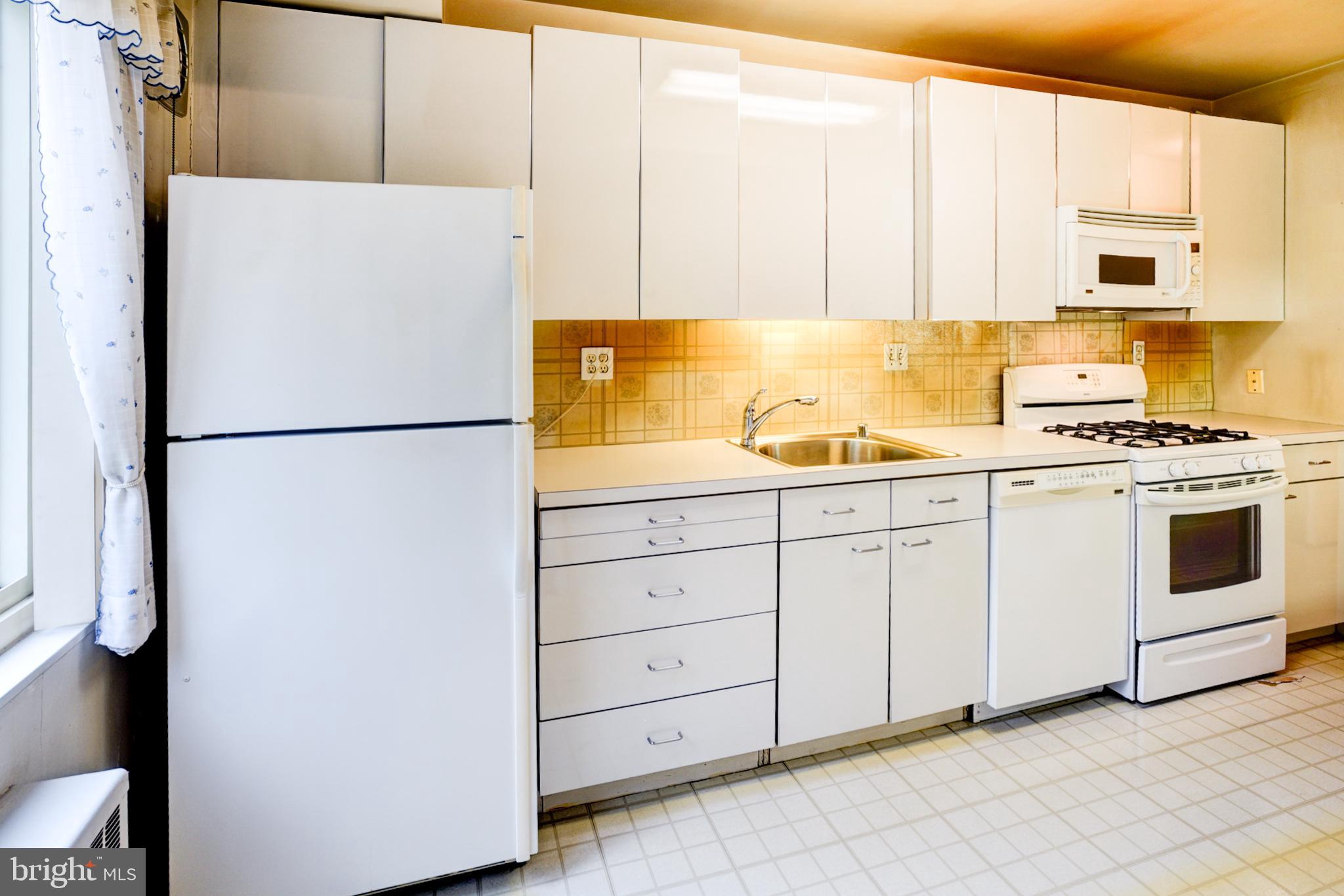 4201 Cathedral Avenue Northwest, Unit 201E Washington, DC 20016 - Photo 19 of 66 a white refrigerator freezer sitting in a kitchen