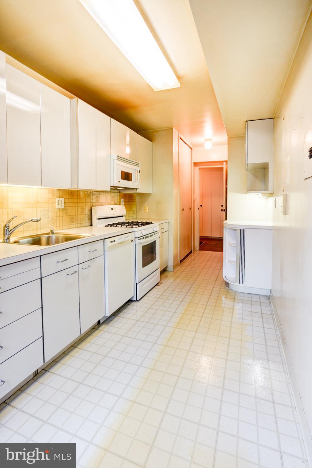 4201 Cathedral Avenue Northwest, Unit 201E Washington, DC 20016 - Photo 20 of 66 a large kitchen with a stove a sink dishwasher and a refrigerator