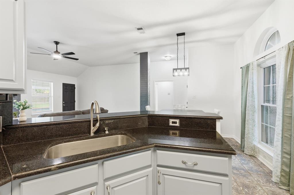217 Seay Road Italy, TX 76651 - Photo 38 of 38 Kitchen with open floor plan, dark stone countertops, white cabinetry, a ceiling fan, and lofted ceiling