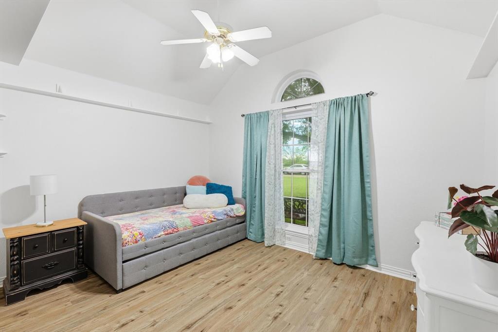 217 Seay Road Italy, TX 76651 - Photo 24 of 38 Bedroom featuring light wood-style flooring, a ceiling fan, and a high ceiling