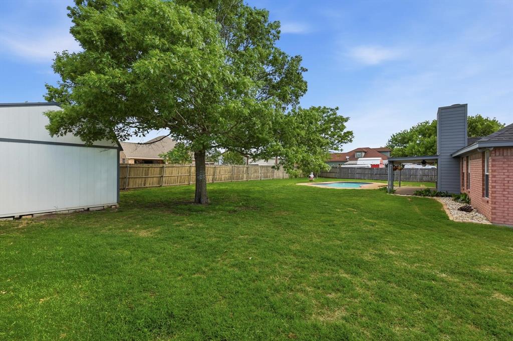 217 Seay Road Italy, TX 76651 - Photo 34 of 38 Fenced backyard with a patio area and an outbuilding