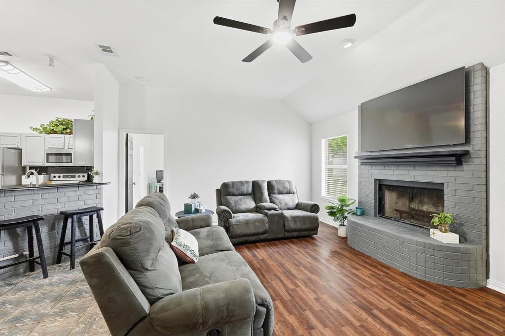 217 Seay Road Italy, TX 76651 - Photo 5 of 38 Living area with a fireplace, vaulted ceiling, ceiling fan, and dark wood-style floors