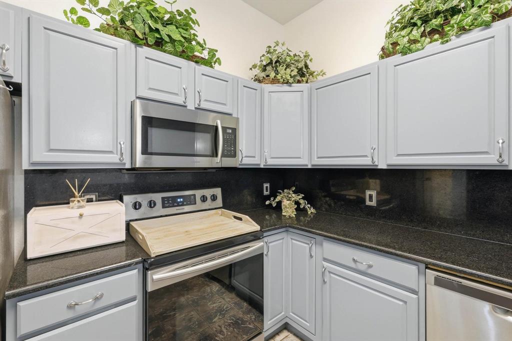 217 Seay Road Italy, TX 76651 - Photo 10 of 38 Kitchen with stainless steel appliances, gray cabinets, and dark stone countertops