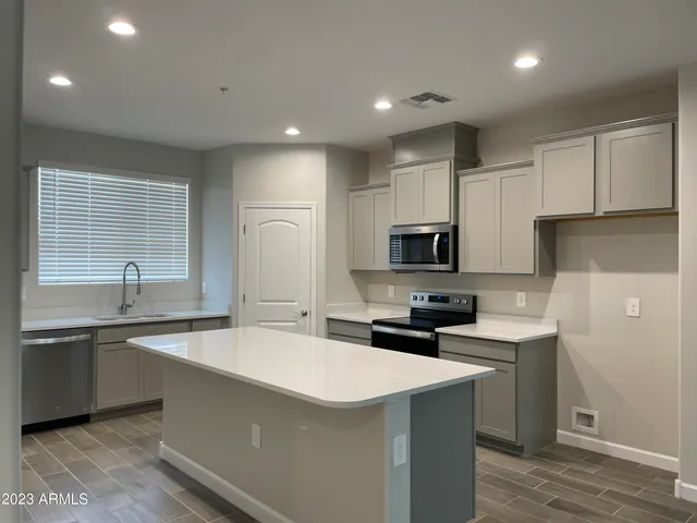 a kitchen with stainless steel appliances a sink stove refrigerator and cabinets