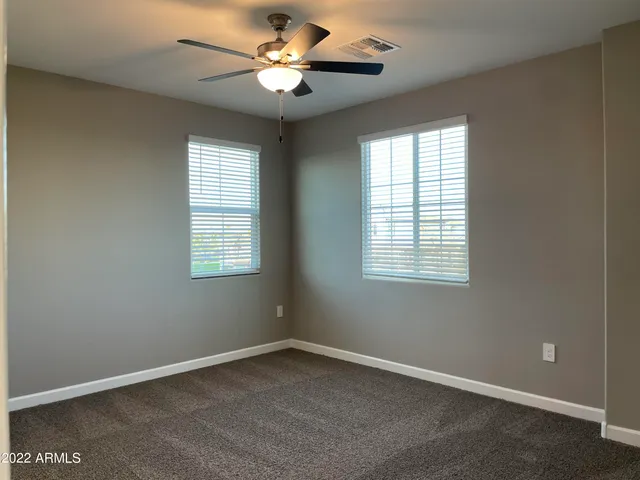 an empty room with a window and a fan