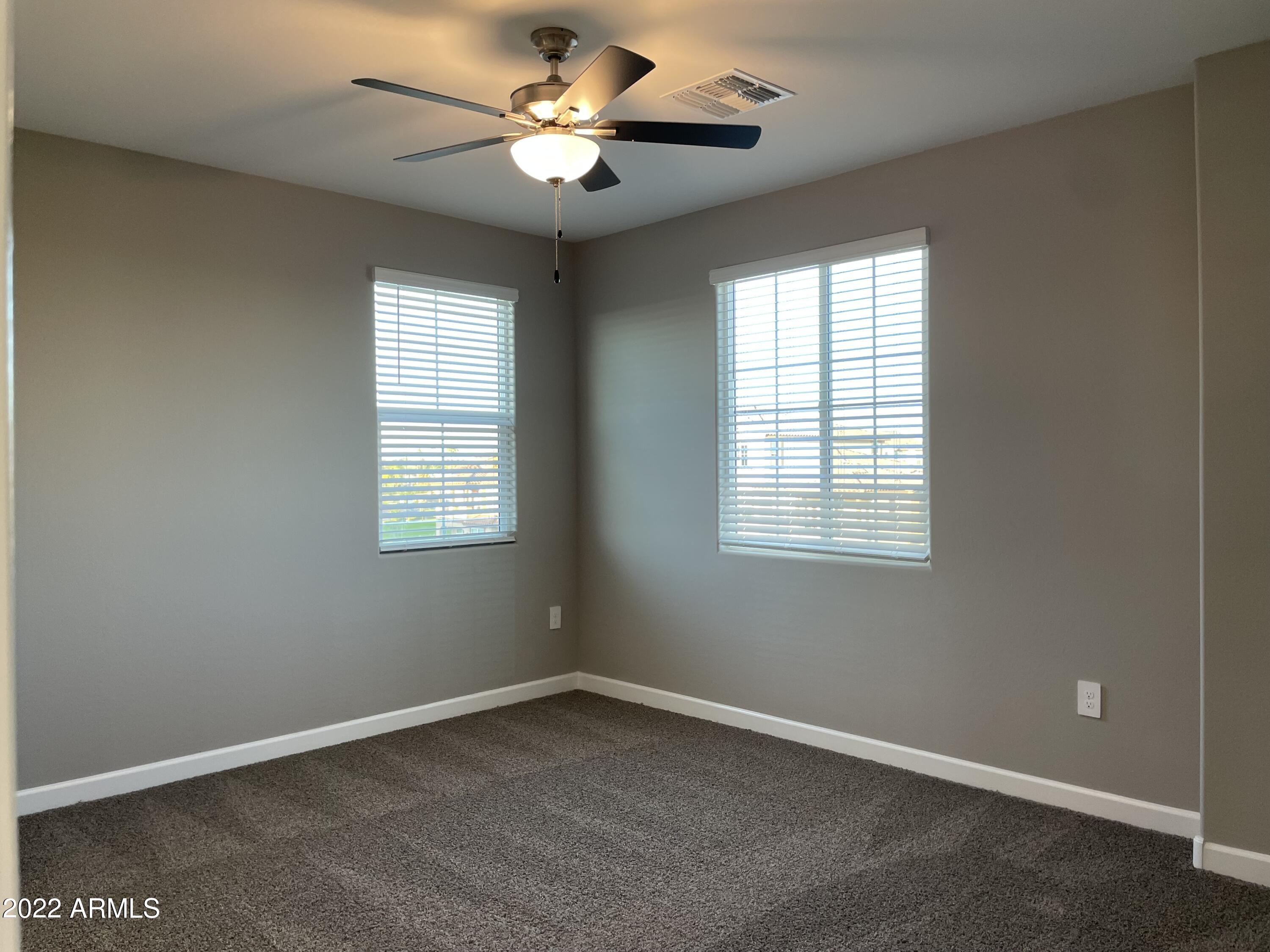 1255 North Arizona Avenue, Unit 1290 Chandler, AZ 85225 - Photo 8 of 13 an empty room with a window and a fan