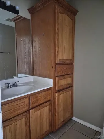 a bathroom with a granite countertop sink and a mirror