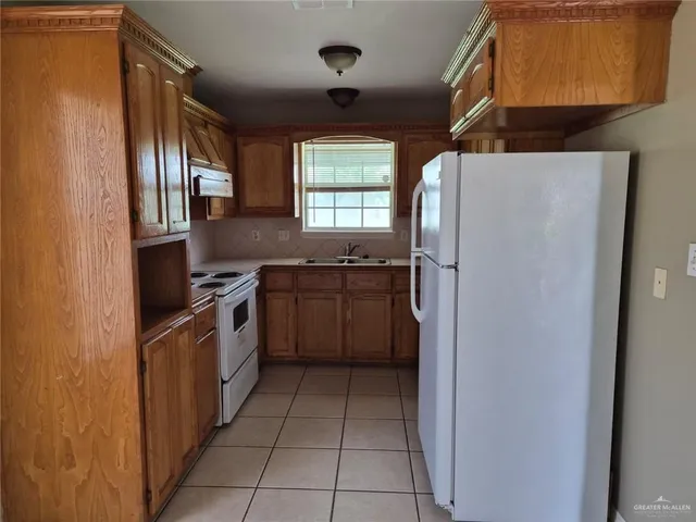 a kitchen with a refrigerator sink and stove top oven