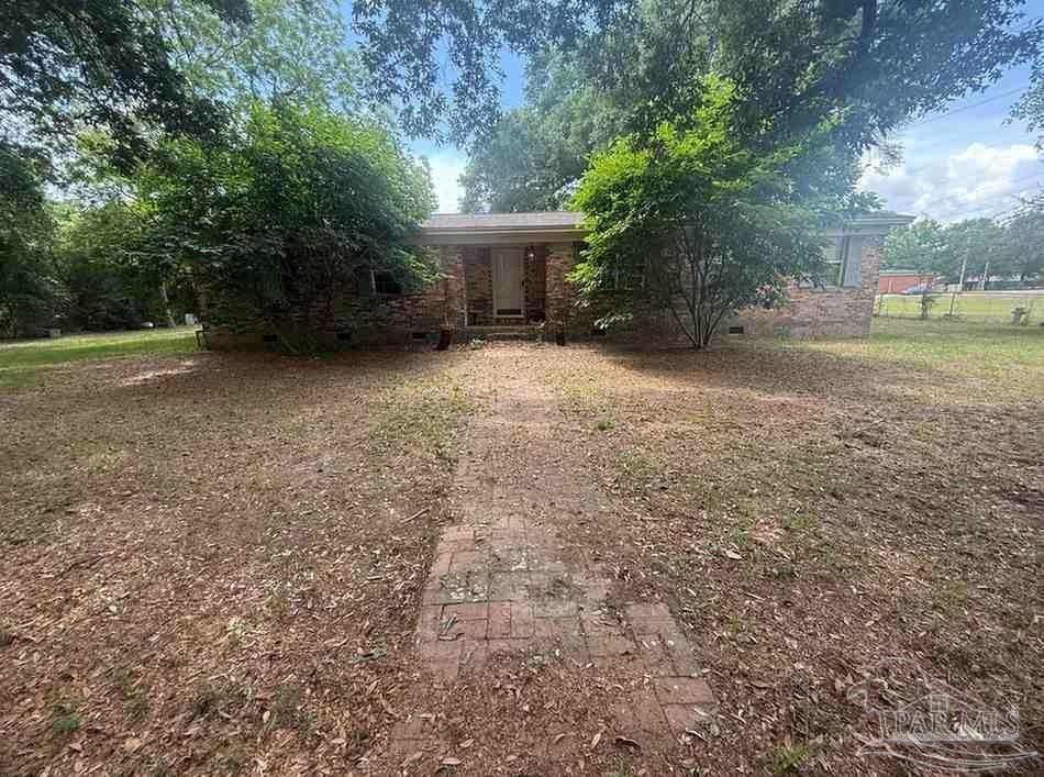 a view of a house with backyard and a tree