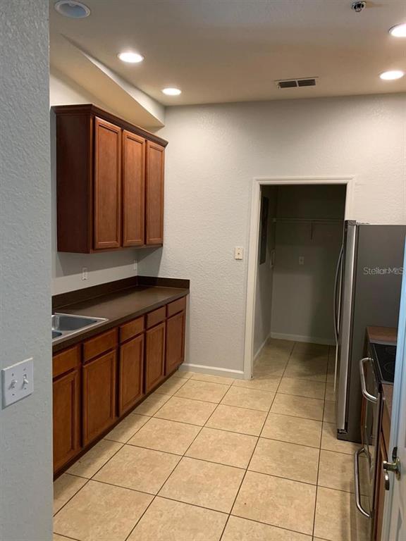 3001 Laurel Run Lane, Unit 301 Kissimmee, FL 34741 - Photo 11 of 17 a kitchen with stainless steel appliances granite countertop a refrigerator and a sink