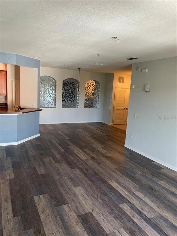 3001 Laurel Run Lane, Unit 301 Kissimmee, FL 34741 - Photo 2 of 17 an empty room with wooden floor and windows