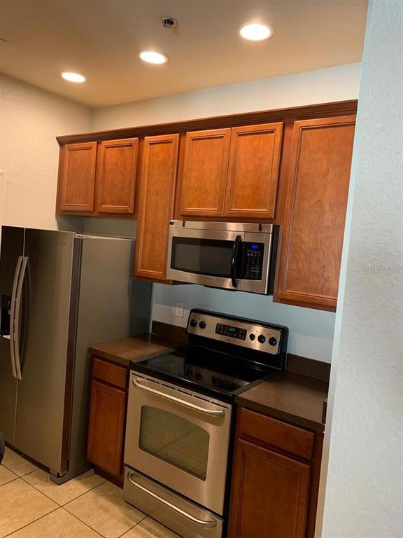 3001 Laurel Run Lane, Unit 301 Kissimmee, FL 34741 - Photo 10 of 17 a kitchen with stainless steel appliances a stove a microwave and a refrigerator