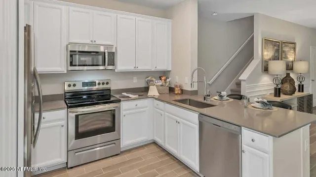 a kitchen with stainless steel appliances granite countertop a sink stove and microwave