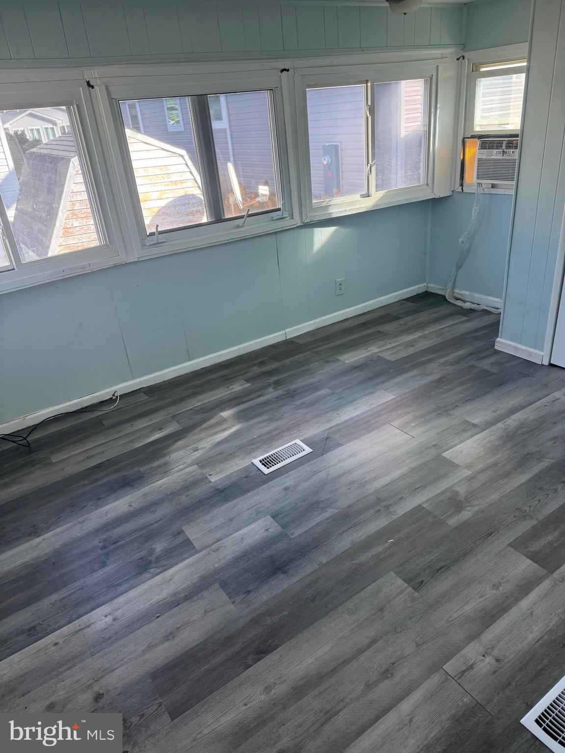 13318 Colonial Road Ocean City, MD 21842 - Photo 8 of 13 an empty room with wooden floor and windows