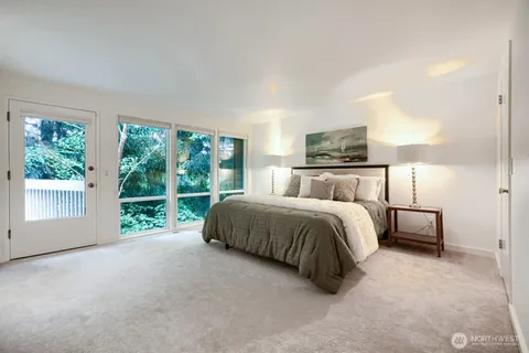 a spacious bedroom with a bed and a large window
