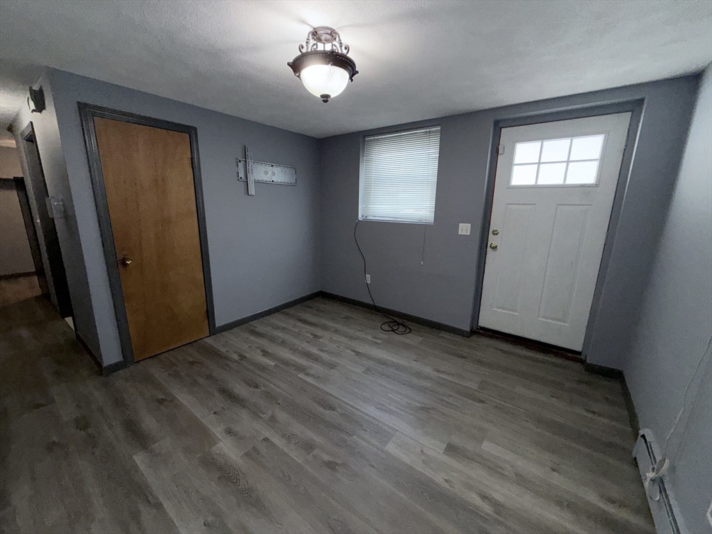 43 Haith Street, Unit B Revere, MA 02151 - Photo 5 of 9 an empty room with wooden floor and windows