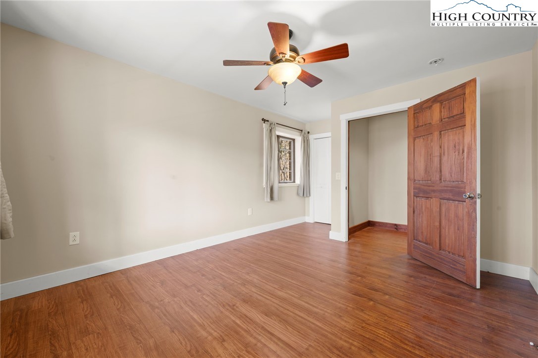 304 Glendale Drive Boone, NC 28607 - Photo 47 of 50 an empty room with wooden floor chandelier fan and windows