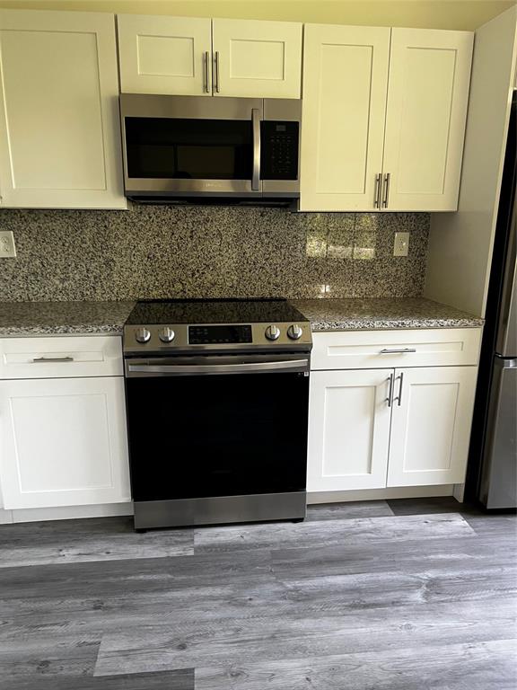 6596 Via Regina, Unit 6596 Boca Raton, FL 33433 - Photo 7 of 16 a kitchen with a stove and a microwave