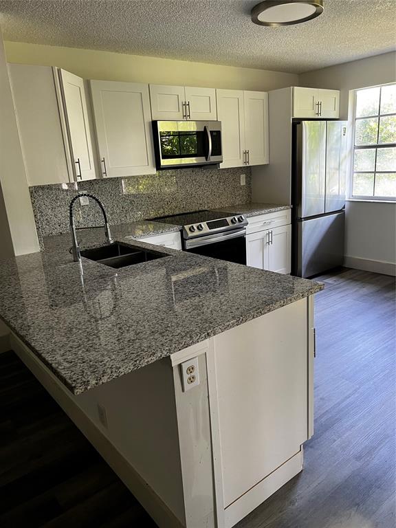 6596 Via Regina, Unit 6596 Boca Raton, FL 33433 - Photo 8 of 16 a kitchen with stainless steel appliances granite countertop a sink a stove and a refrigerator