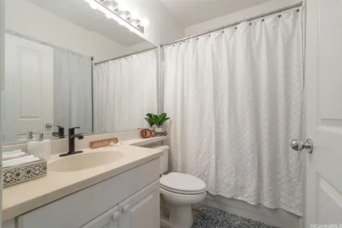 a bathroom with a sink a toilet and shower curtain