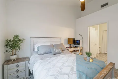 a bedroom with a bed and a flat tv screen on a dresser