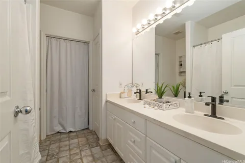 a bathroom with a double vanity sink a mirror and shower