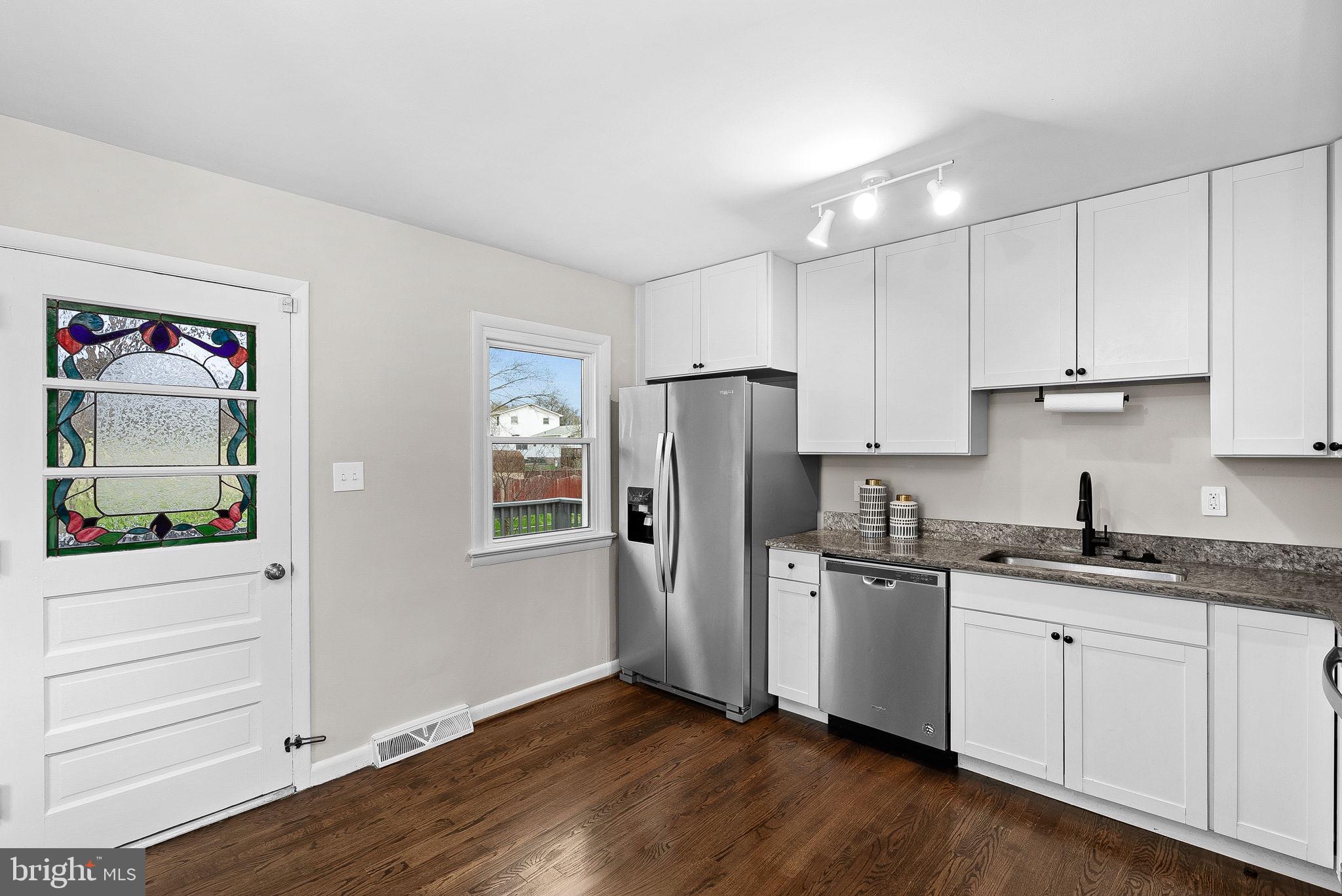 647 Battle Avenue Winchester, VA 22601 - Photo 15 of 44 a kitchen with stainless steel appliances granite countertop a refrigerator sink and white cabinets