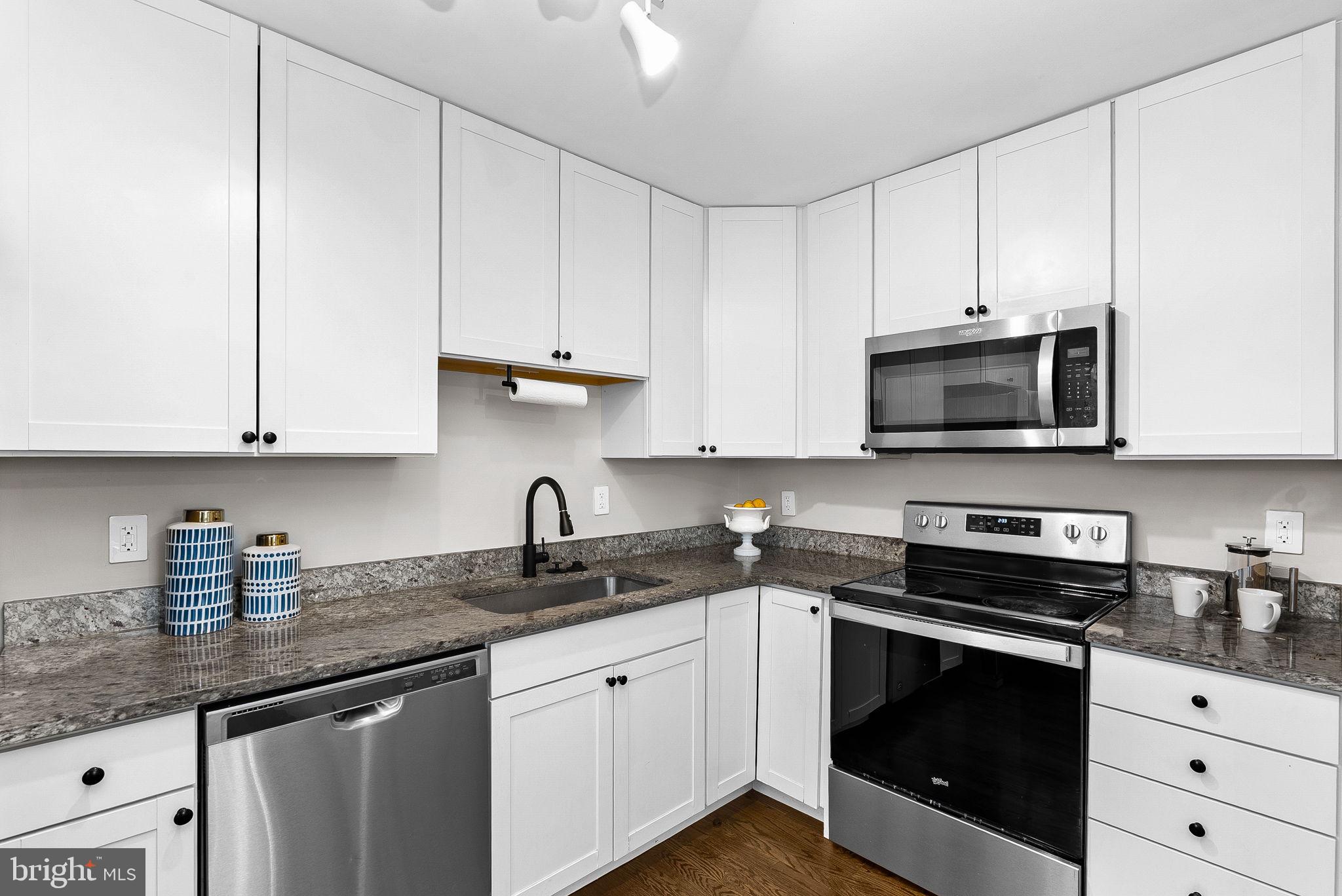 647 Battle Avenue Winchester, VA 22601 - Photo 17 of 44 a kitchen with white cabinets and black appliances