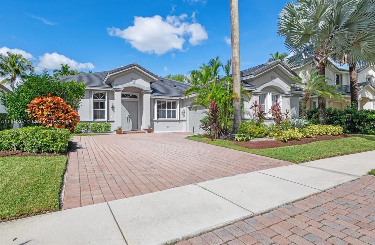 a front view of a house with a yard and potted plants