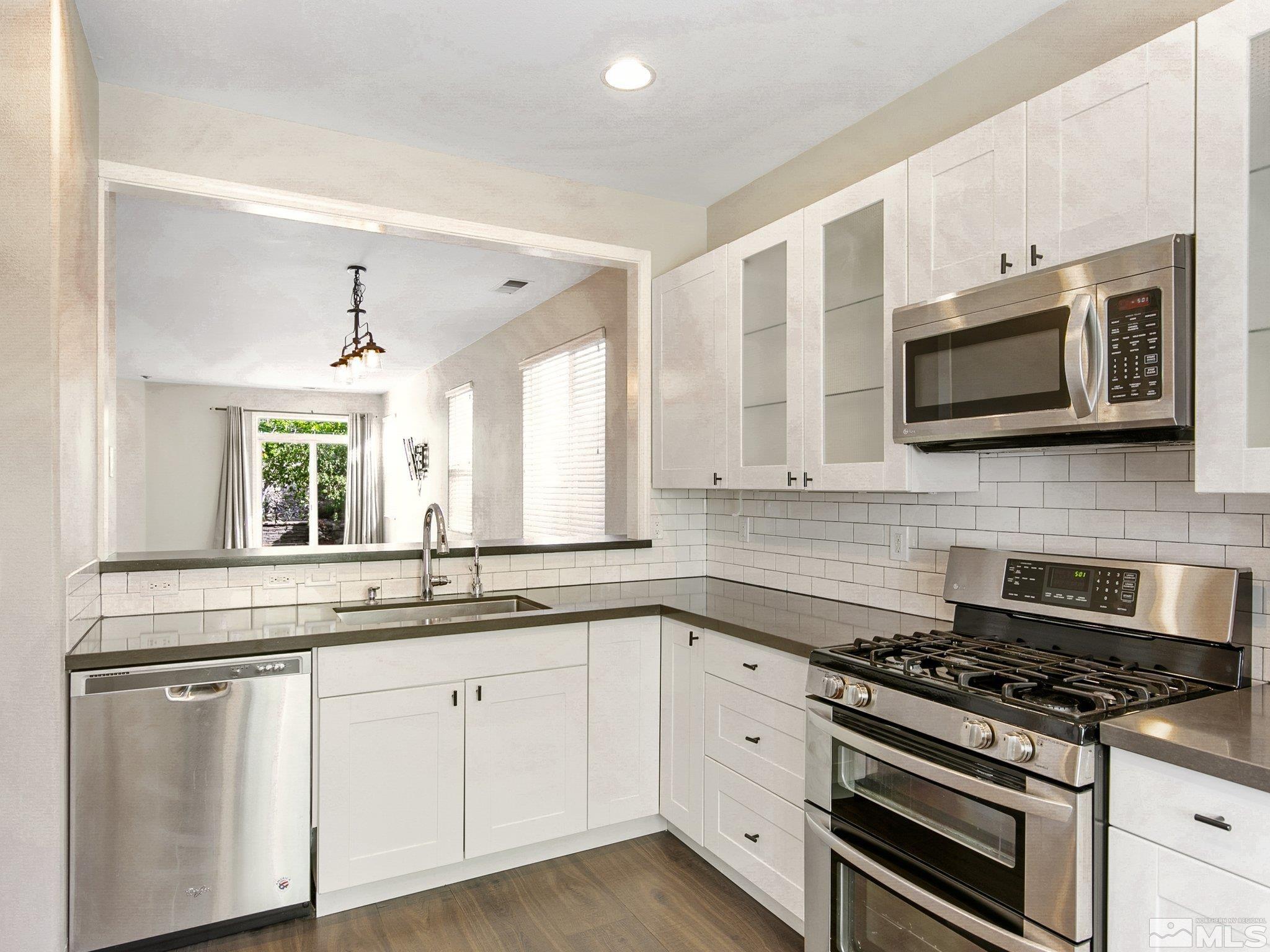 2348 Clementine Lane Reno, NV 89521 - Photo 11 of 38 a kitchen with stainless steel appliances a stove microwave and sink